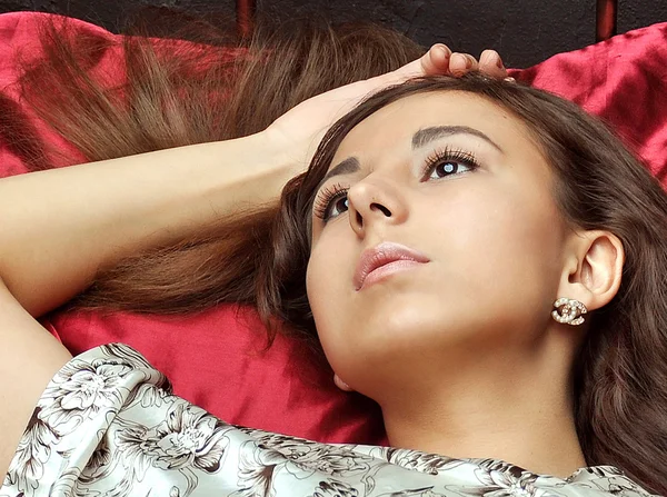 Kaukaski kobieta leży na jawie w łóżku czerwony — Zdjęcie stockowe