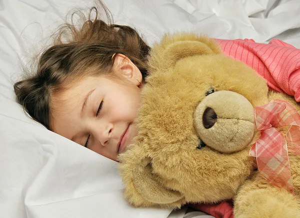 Mała dziewczynka śpi w łóżku — Zdjęcie stockowe