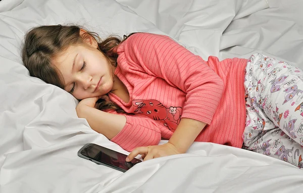 Klein meisje viel in slaap met de telefoon — Stockfoto