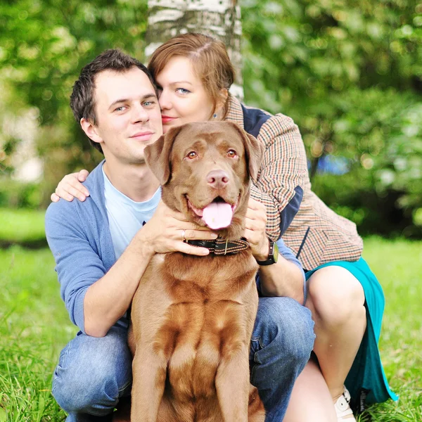 Happy young family with labrador — Stock Photo, Image