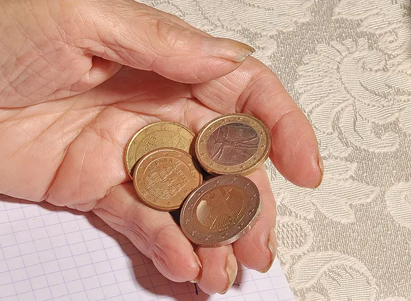 Mãos de uma velha segurando uma moeda — Fotografia de Stock