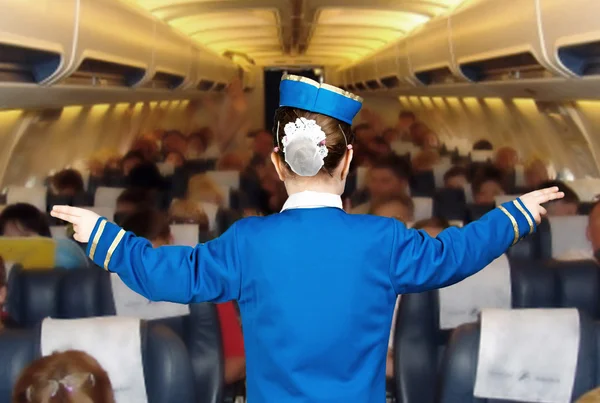 Дівчина в костюмі стюардеса показує напрямок — стокове фото