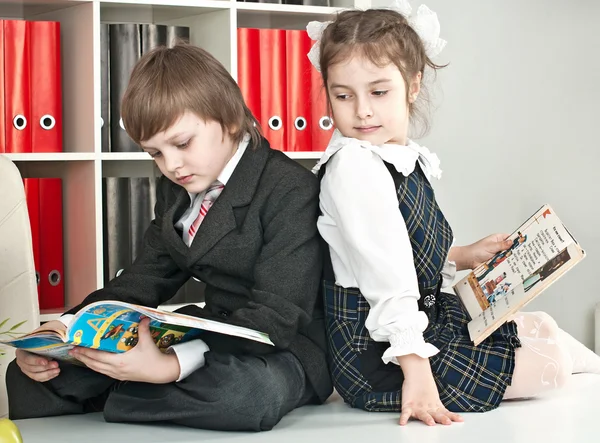 Menino e menina sentados em uma mesa na escola — Fotografia de Stock