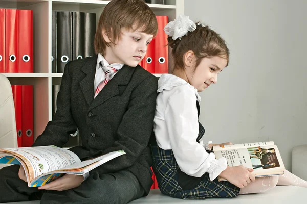 Chłopiec i dziewczynka siedzi na biurku w szkole — Zdjęcie stockowe