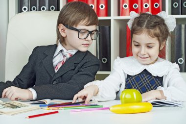 Kitaplar ile okul bir masada oturan kız ve erkek