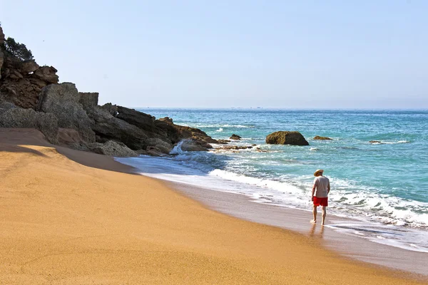 Samotny człowiek spacerujący po plaży — Zdjęcie stockowe