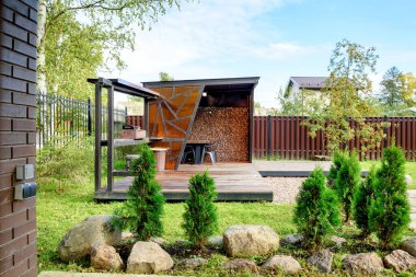 Mangal ızgarası, masa ve sandalyeli piknik alanı.