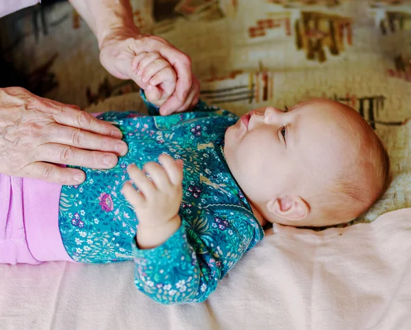 一个年长的祖母牵着一个3个月大的小女孩的手 — 图库照片