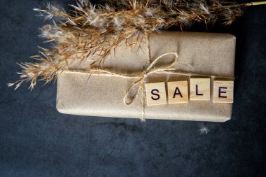Ağda kağıdında hediye kutusu olan bir alışveriş sepeti. Çevrimiçi alışveriş kavramı. Noel indirimi ya da hediye alışverişi. Yılbaşı ve Noel için indirim. Hediyeler alıyorum..