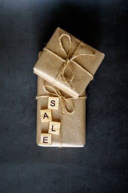 Ağda kağıdında hediye kutusu olan bir alışveriş sepeti. Çevrimiçi alışveriş kavramı. Noel indirimi ya da hediye alışverişi. Yılbaşı ve Noel için indirim. Hediyeler alıyorum..