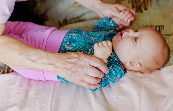 一个年长的祖母牵着一个3个月大的小女孩的手 — 图库照片