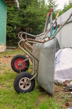 Çite yaslanmış iki el arabası. Bahçıvanlık.