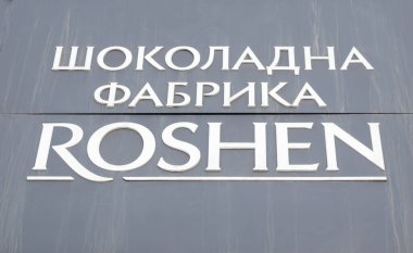 Kiev 'deki Roshen Çikolata Fabrikası' nın ana girişi. Ukraynaca beyaz harfler, siyah bir tabela üzerinde. Roshen şirketinin amblemi. Ukrayna, Kiev - 09 Şubat 2022