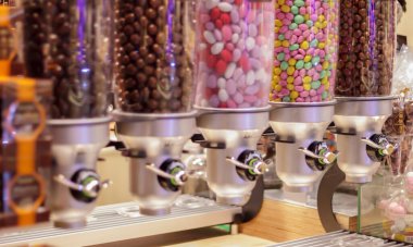 Şekercideki plastik tüplerdeki renkli meyve şekerlemeleri. Markette satılık jelibon. Pasta makinesinde renkli sakız topları. Seçici odak