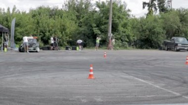 Sürüklenen araba, profesyonel sürücü. Yanan lastiklerden çıkan yoğun dumanlı yarış arabası. Yarış arabası arızası. Rus hareket fiziğinde araba metniyle. Ukrayna, Kiev - 22 Temmuz 2021.