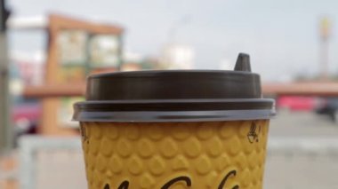 McDonalds 'dan sarı karton kahve fincanı. Mc Cafe kağıt bardak içeceği. Masada bir fincan sıcak çay ya da kahve olsun. Fast food restoranının menüsü. Ukrayna, Kiev - 12 Eylül 2021.