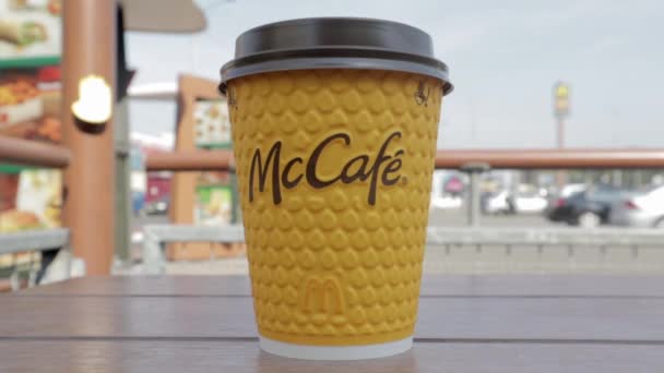 男性の手を閉じると マクドナルドのコーヒーをMccafe黄色の紙コップに入れます 持ち帰り用の食品 男はファーストフード店でホットコーヒーや紅茶を飲む スローモーション ウクライナ キエフ 2021年9月12日 — ストック動画