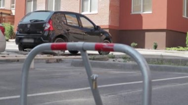 Gri bir park kilidi. Yakın çekim video. Park yeri rezervasyonu, katlanabilir engeller. Otoparkın güvenlik engeli buraya park edilmesini engelliyor..