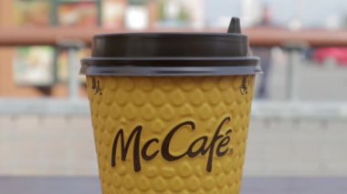 McDonalds 'dan sarı karton kahve fincanı. Mc Cafe kağıt bardak içeceği. Masada bir fincan sıcak çay ya da kahve olsun. Fast food restoranının menüsü. Ukrayna, Kiev - 12 Eylül 2021.