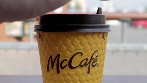 男の手は黄色い紙のコーヒーカップの上にプラスチック製の蓋を開ける 持ち帰り用の食品 マクドナルドのファーストフード店でホットコーヒーや紅茶を飲む男 ウクライナ キエフ 2021年9月12日 — ストック動画