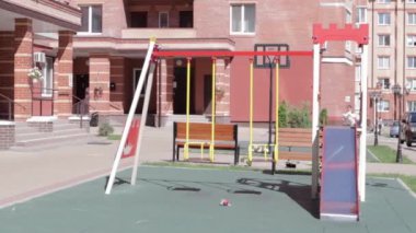 Parktaki bahçedeki renkli, modern çocuk parkında, rahatlatıcı ve oyuncu çocuklar var. Yeşil ağaçlar ve yeni evlerle çevrili bir parkta oyun parkı. Ukrayna, Kyiv - 29 Haziran 2021.