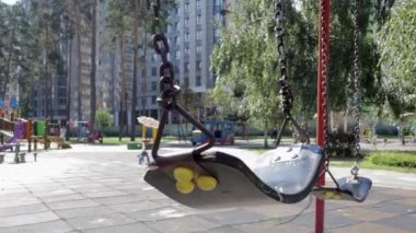 Parktaki boş bebek salıncağını kapat. Yeni zincir salıncak. Modern bir oyun bahçesinde siyah salıncak zinciri. Bulanık arkaplandaki salıncağa odaklan.