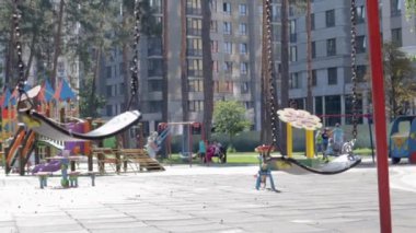 Parktaki boş bebek salıncağını kapat. Yeni zincir salıncak. Modern bir oyun bahçesinde siyah salıncak zinciri. Bulanık arkaplandaki salıncağa odaklan. Ukrayna, Kiev - 19 Ağustos 2021.