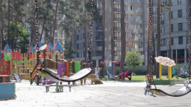 Parktaki boş bebek salıncağını kapat. Yeni zincir salıncak. Modern bir oyun bahçesinde siyah salıncak zinciri. Bulanık arkaplandaki salıncağa odaklan. Ukrayna, Kiev - 19 Ağustos 2021.