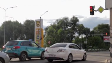 Yeşil ışıkta arabaları taşımak. Yollardaki yeşil trafik ışığı caddesi otoyolda yavaşça ilerliyor. Trafik ışığı kırmızı, sarı ve yeşile geçiyor. Ukrayna, Kyiv - 7 Ağustos 2021.