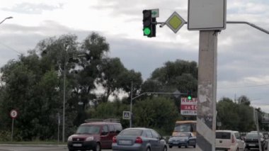 Yeşil ışıkta arabaları taşımak. Yollardaki yeşil trafik ışığı caddesi otoyolda yavaşça ilerliyor. Trafik ışığı kırmızı, sarı ve yeşile geçiyor. Ukrayna, Kyiv - 7 Ağustos 2021.