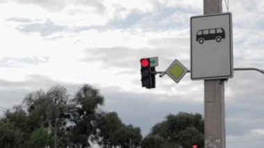 Otobüs durağı ve trafik ışığı. Otobüs durağı tabelası, gündüz vakti mavi gökyüzüne karşı..