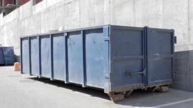 İnşaat alanındaki açık hava çöpleri için metal dayanıklı mavi endüstriyel çöp kutusu. Ev ya da endüstriyel atıklar için büyük bir çöp kutusu. Bir çöp yığını..