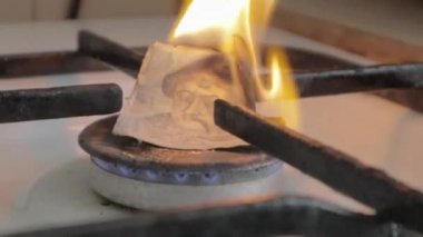Ukrayna 'nın Hryvnia' sı bir gaz ocağında ateşle yanıyor. Paralı gaz ocağı. Ukrayna nüfusu için artan tarifenin kavramsal görüntüsü. Ülkede doğalgaz tasarrufu kavramı, yüksek benzin fiyatları.