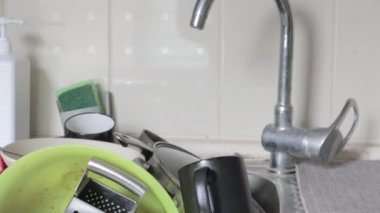 Lavabodaki mutfak aletlerinin yıkanması gerekiyor. Mutfak lavabosunda bir yığın kirli bulaşık. Mutfak aletlerinin yıkanması gerekiyor. Ödev konsepti.
