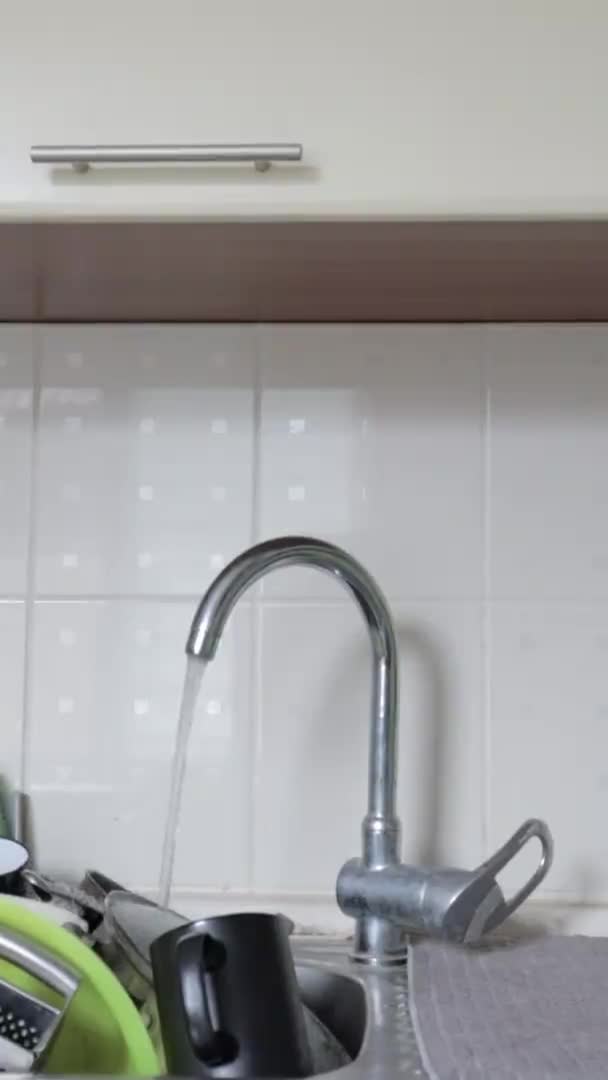 洗脸盆里的厨房用具必须洗净 垂直录像 厨房水池里有一堆脏兮兮的盘子 里面有自来水 厨房用具需要洗一洗 家庭工作概念 — 图库视频影像