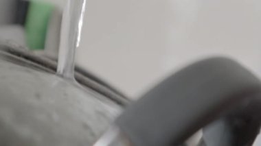 Lavabodaki mutfak aletlerinin yıkanması gerekiyor. Mutfak lavabosunda akan suyla birlikte bir yığın kirli bulaşık. Mutfak aletlerinin yıkanması gerekiyor. Ödev konsepti.