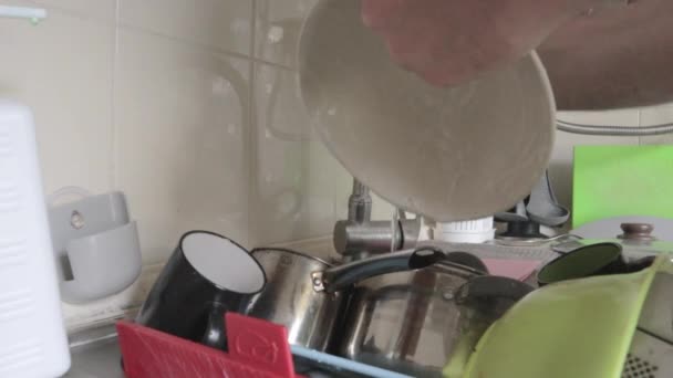 クローズアップ男性の手は 泡の洗濯布で台所のシンクで汚れて脂っこいプレートを洗浄します 石鹸泡と泡 緑色のスポンジで皿をきれいにしてきれいにする — ストック動画