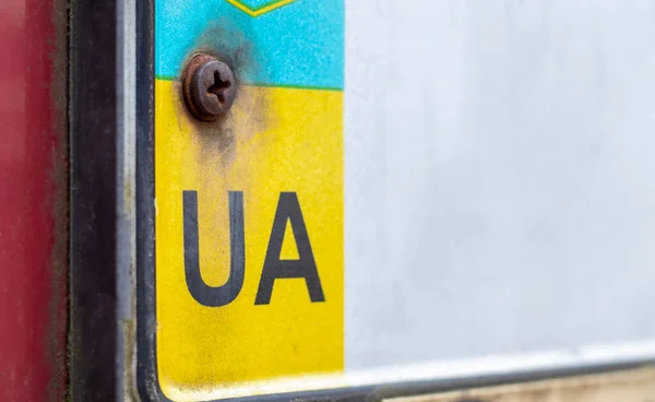 Part of the Ukrainian license plate on the bumper close-up. The symbol of nationality on the background of the colors of the flag. Individual registration plate of the vehicle