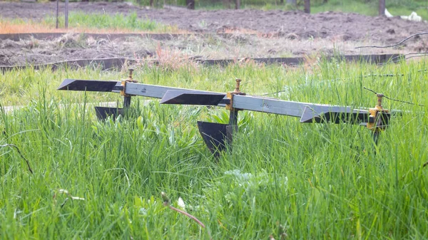 Tarımsal manuel metal tarla tarlasında. Ekmeden önce toprağı sürüyorum. Yakın plan. Kırsalda patates sürme envanteri. Saban, yoğun toprağı sürmek ve bakir toprağı işlemek için kullanılan bir araçtır.