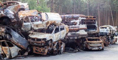 Paslı yanan arabalar roket patlamalarıyla yok edildi. Ukrayna 'da savaş. Bucha ve Irpin 'den ayrılan sivil araçları savaş alanından tahliye edildi. Araba mezarlığı.