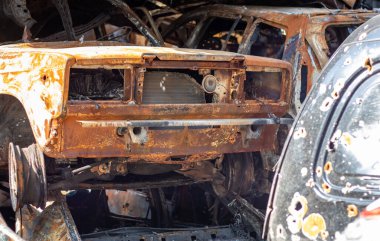 Araba tamamen yandı, lastikler bile yandı. Yangından sonra araba kazası geçirmiş. Terörist saldırısının bomba mermisi sivilleri havaya uçurdu. Felaket bölgesi. Terk edilmiş araba yolda.