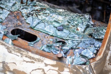 Araba tamamen yangın tarafından tahrip edildi. Yol kenarında terk edilmiş, yanmış ve paslı bir araba. Arabalar otoparkta yanıyordu. Rusya 'nın Ukrayna' ya karşı savaşı. Arabalarda şarapnel ve kurşun delikleri var.