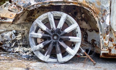 Araba tamamen yangın tarafından tahrip edildi. Yol kenarında terk edilmiş, yanmış ve paslı bir araba. Arabalar otoparkta yanıyordu. Rusya 'nın Ukrayna' ya karşı savaşı. Arabalarda şarapnel ve kurşun delikleri var.