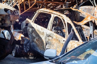 Araba tamamen yandı, lastikler bile yandı. Yangından sonra araba kazası geçirmiş. Terörist saldırısının bomba mermisi sivilleri havaya uçurdu. Felaket bölgesi. Terk edilmiş araba yolda.