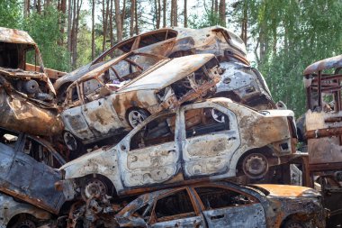 2022 'de Rusya' nın Ukrayna 'yı işgali, arabaları yok etti ve yaktı. Arabalar şarapnelle dövülmüş ve yakılmış. Irpensky otomobil mezarlığı. Kyiv yakınlarındaki huzurlu bir şehirde savaşın sonuçları.