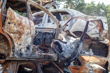 Rus ordusunun roket saldırılarından sonra yanmış arabaların görüntüsü. Rusya 'nın Ukrayna' ya karşı savaşı. Yangından sonra sivil araç. Irpin şehrindeki araba mezarlığı. Paslı metal yığını