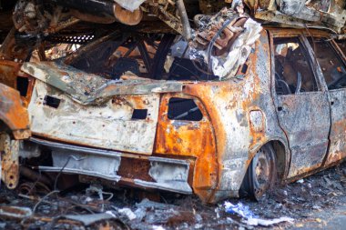Rus ordusunun roket saldırılarından sonra yanmış arabaların görüntüsü. Rusya 'nın Ukrayna' ya karşı savaşı. Yangından sonra sivil araç. Irpin şehrindeki araba mezarlığı. Paslı metal yığını