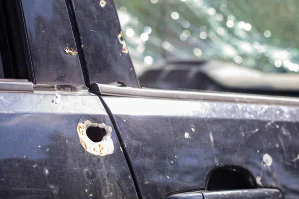 Araba kurşunla delik deşik olmuş. Rusya 'nın Ukrayna' ya karşı savaşı. Kadın ve çocukların tahliyesi sırasında Rus ordusu tarafından vurulan bir sivil arabası. Mermi izleri ve kovan parçaları.