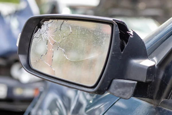 Close up broken left side rearview mirror of a car in blue. Auto insurance concept. Broken side glass of the car on the driver\'s side as a result of an accident. Criminal incident