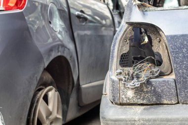 Caddedeki bir restorasyon istasyonunun otoparkındaki bir trafik kazasından sonra birçok araba bozuldu. Dışarıda araba hasar atölyesi var. Açık artırmada sigorta acil durum araçları satışı